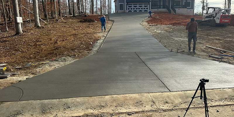 Aggregate concrete driveway in front of residential property undergoing a home remodeling job